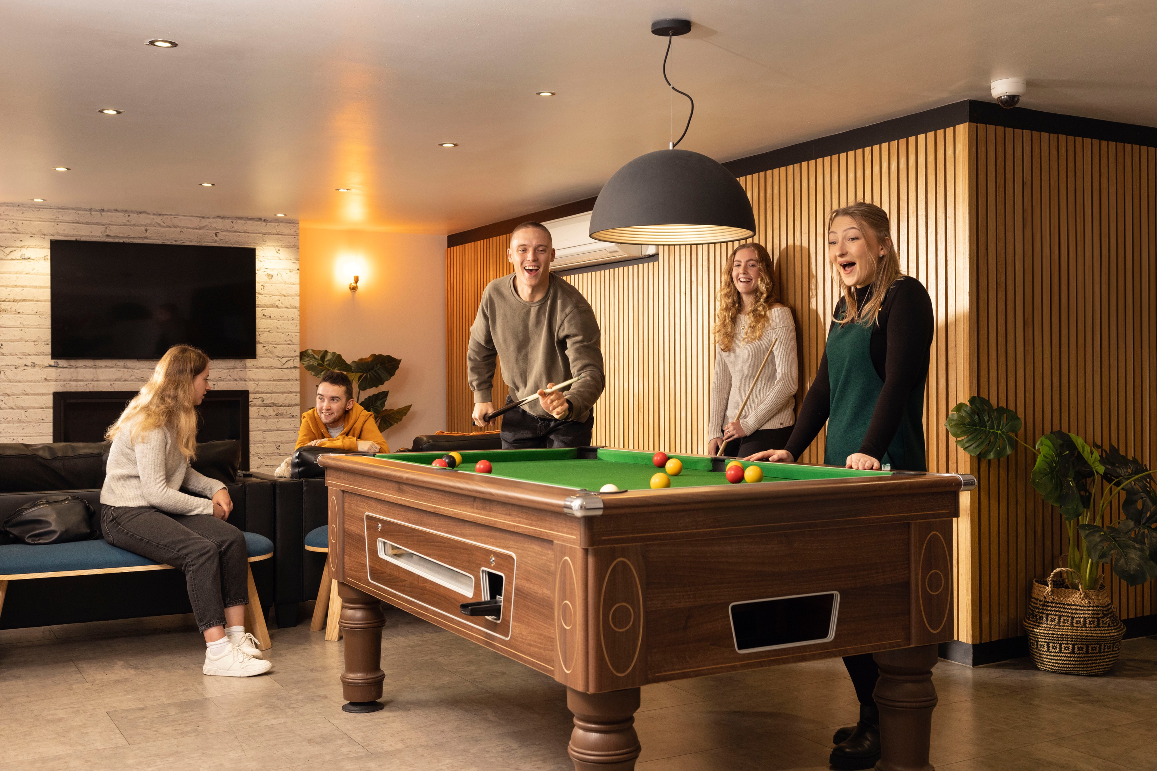 Students playing pool in games area