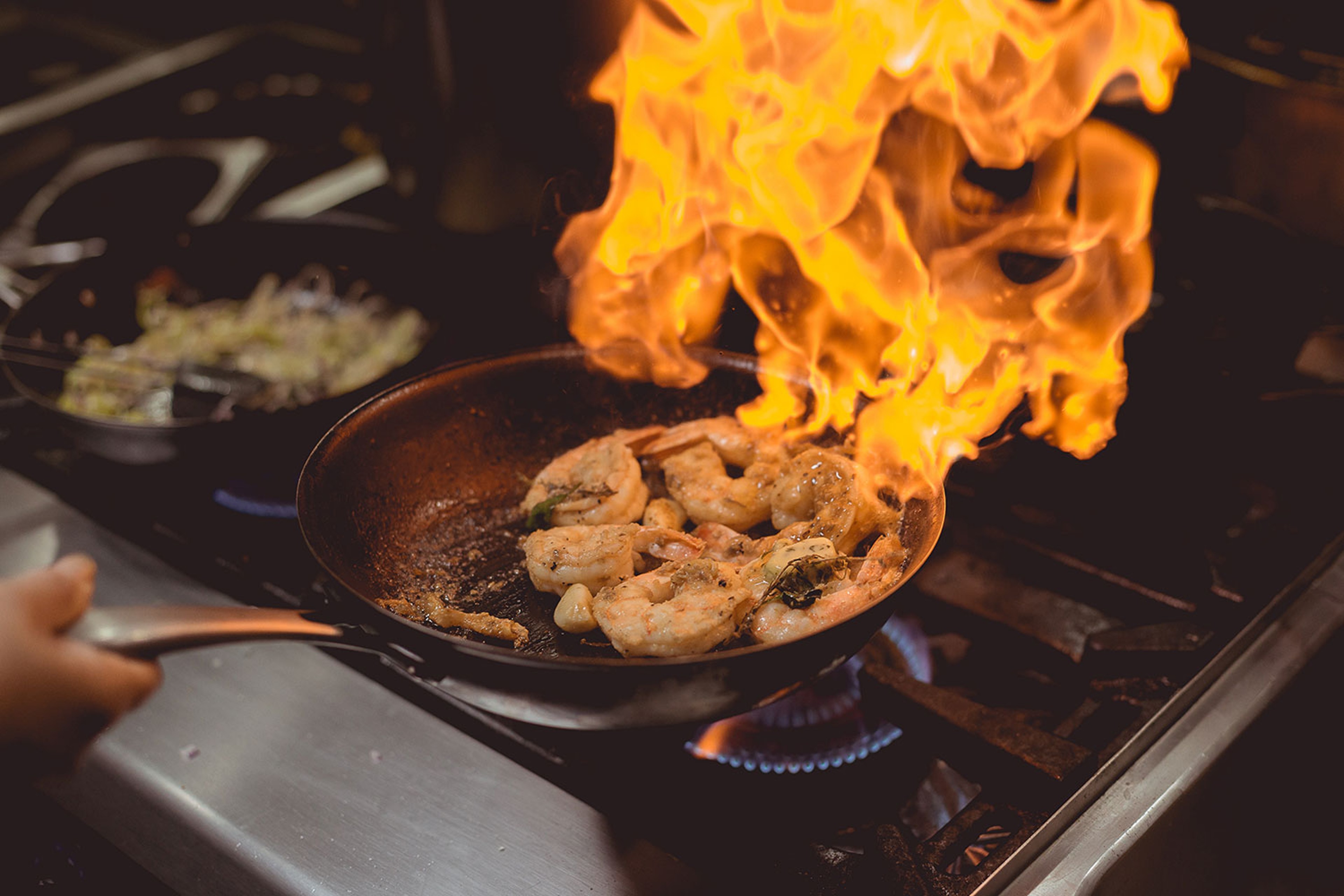 Person frying chicken with open flame