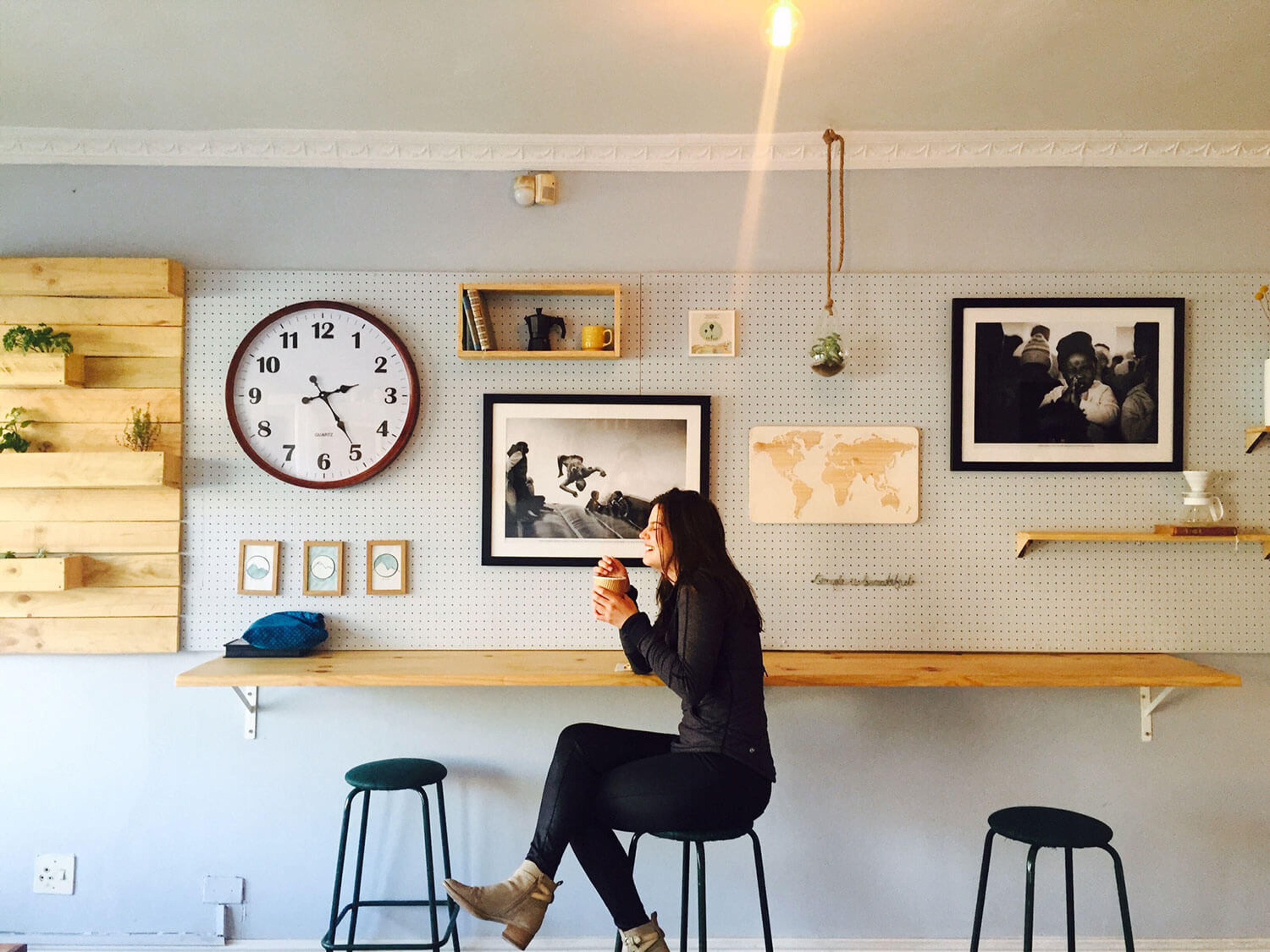 Woman sat on a stool drinking coffee