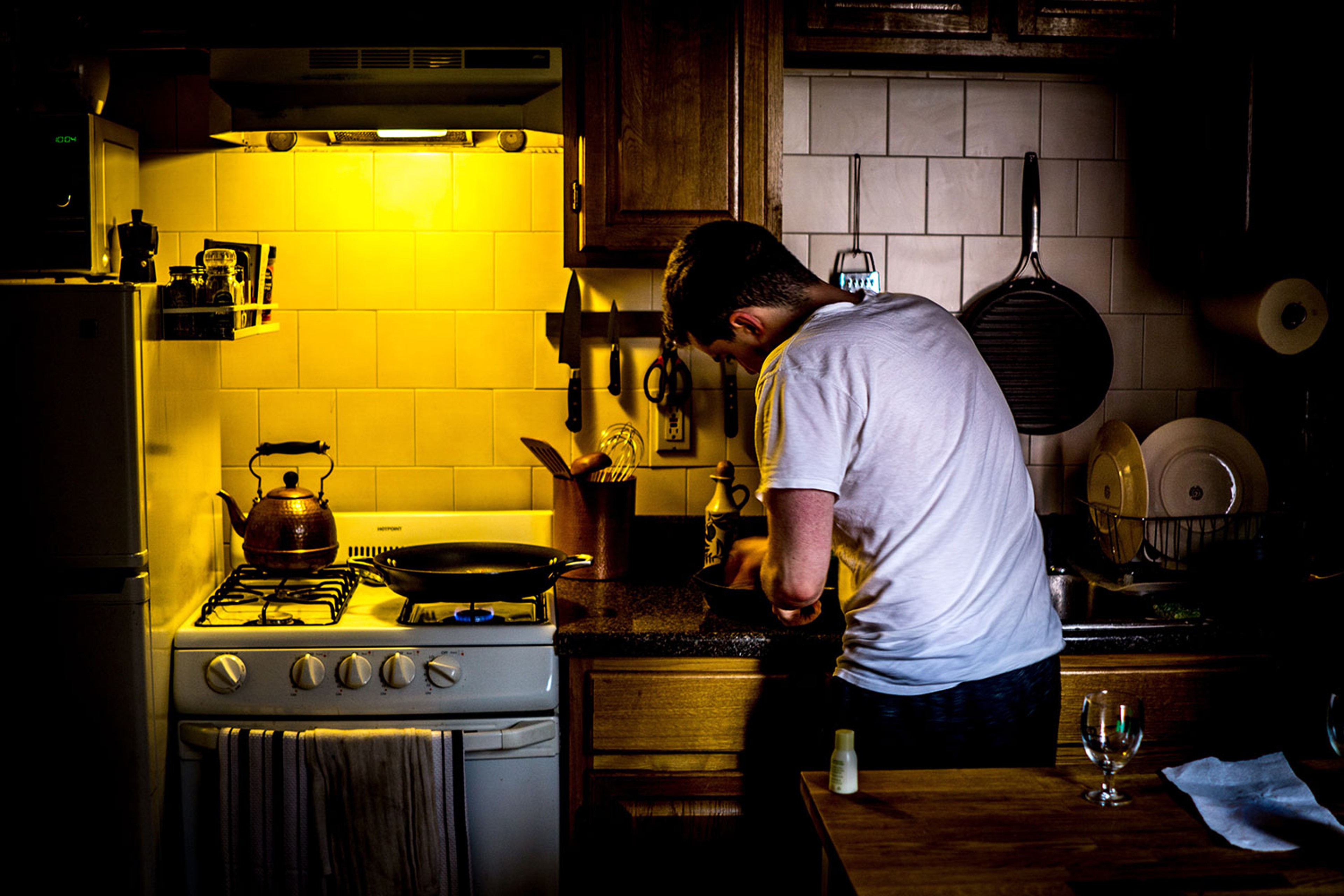Boy stood over hob cooking