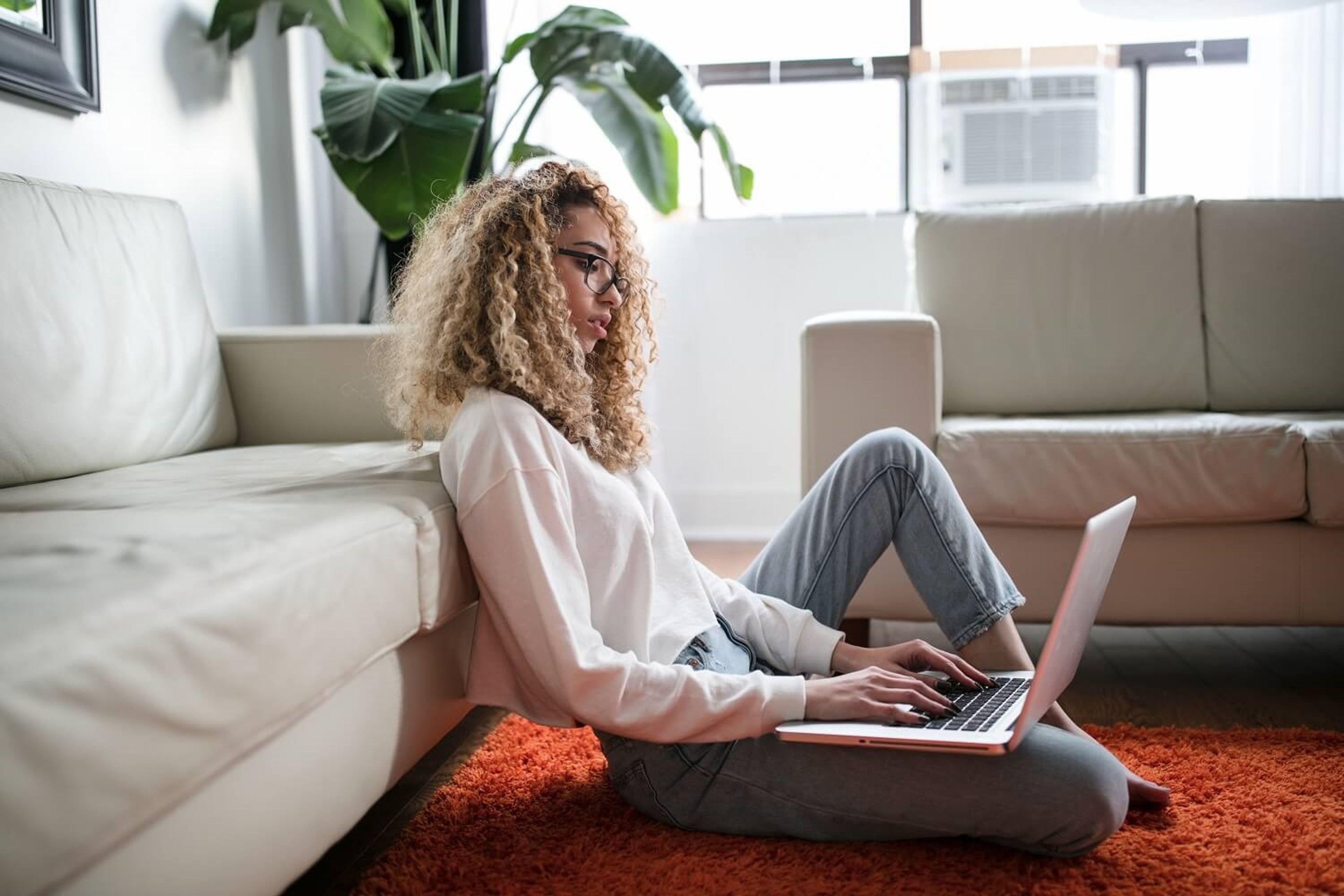 Young woman on a laptop sat on the floor