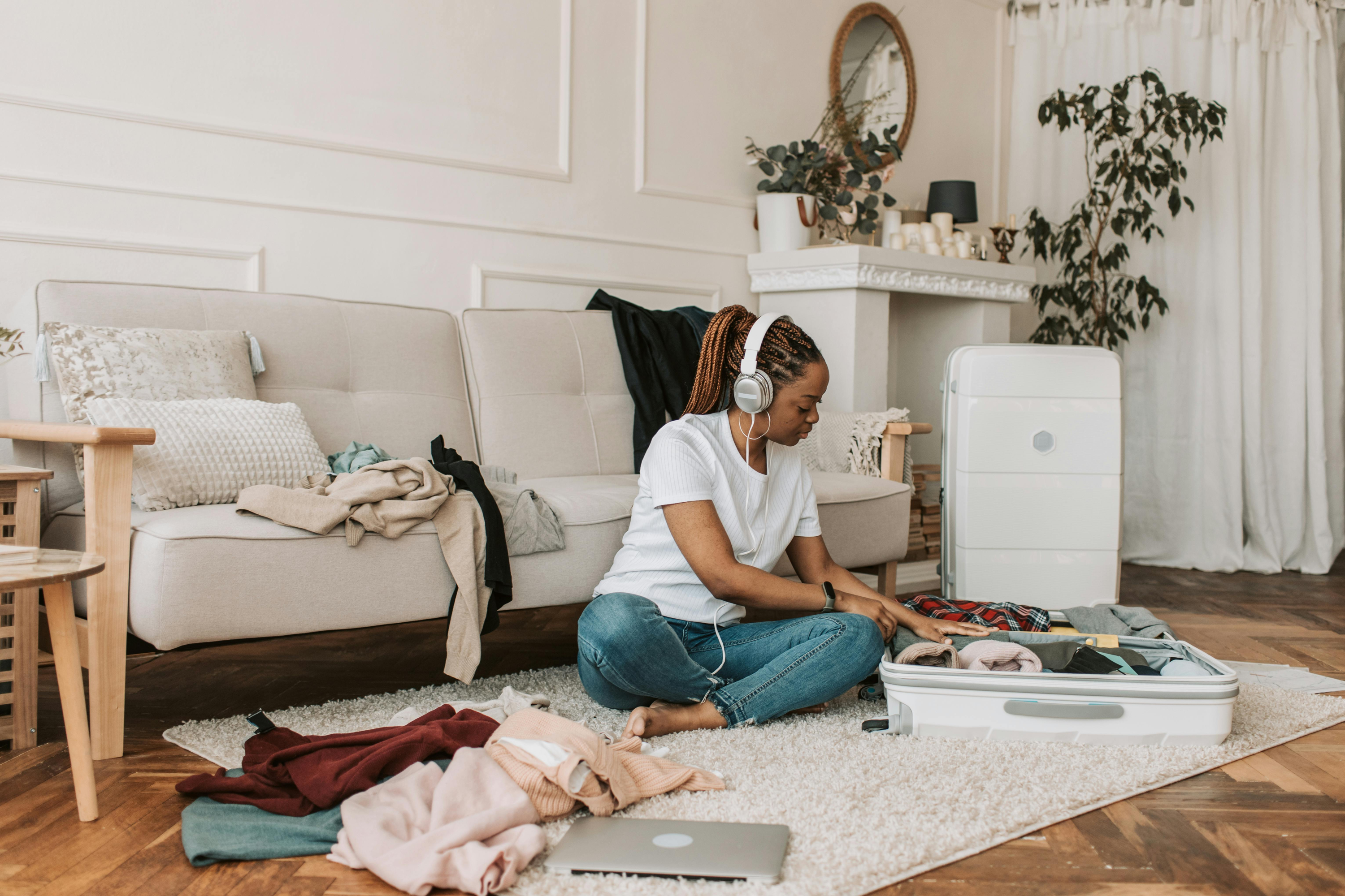 Girl sat packing two suitcases on floor