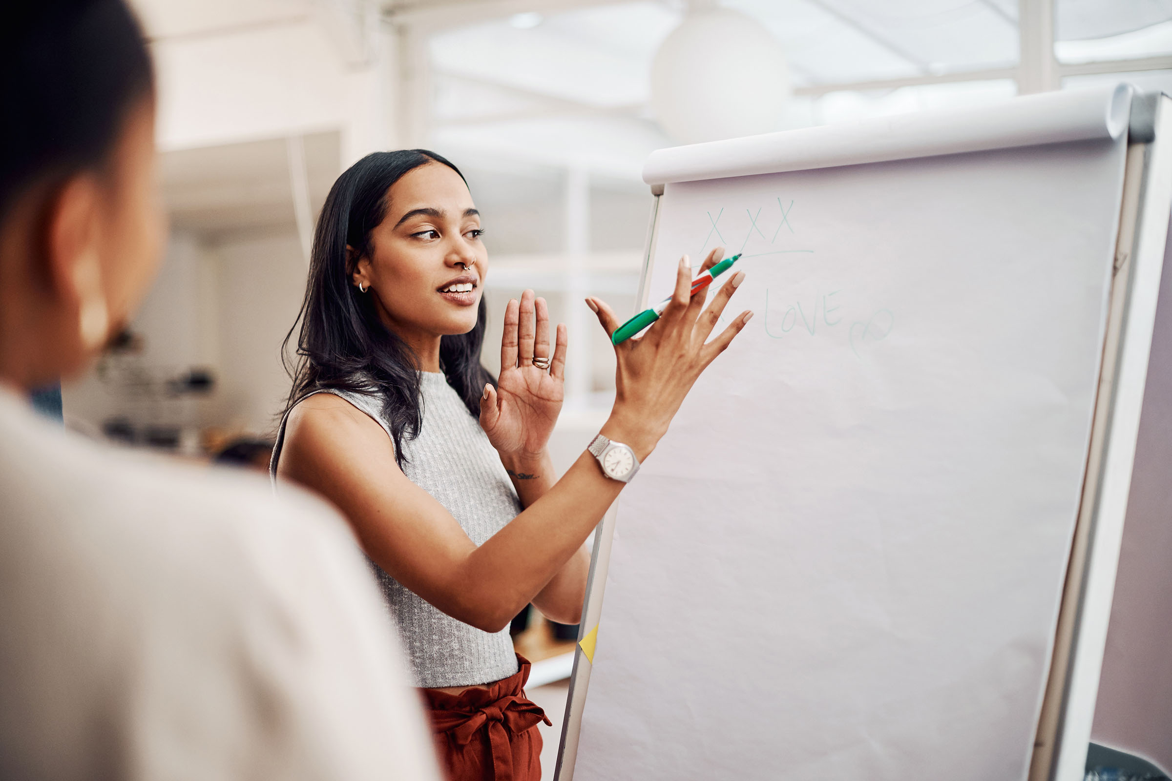 Woman holding pen talking by an A-board