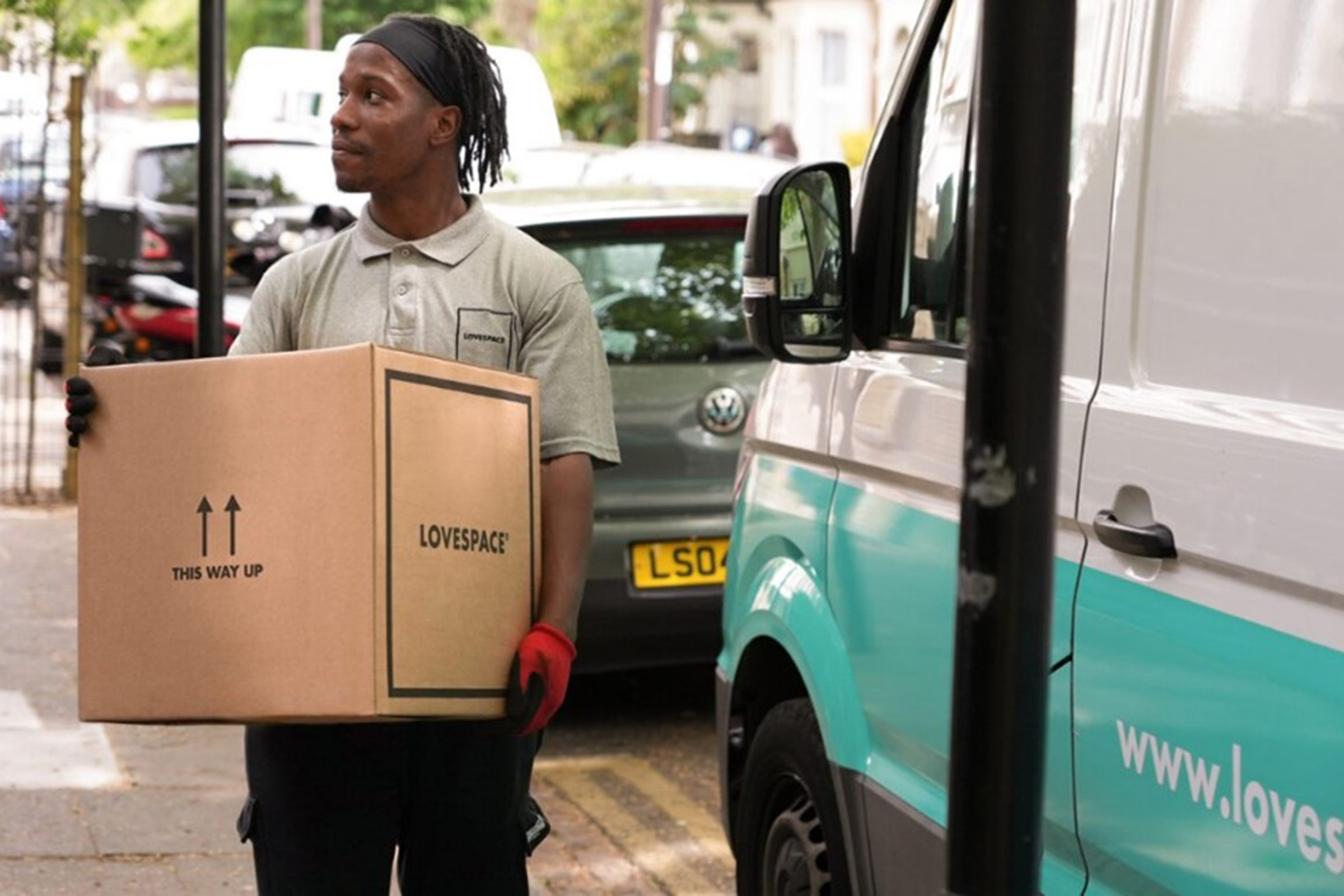 Lovespace member carrying cardboard box