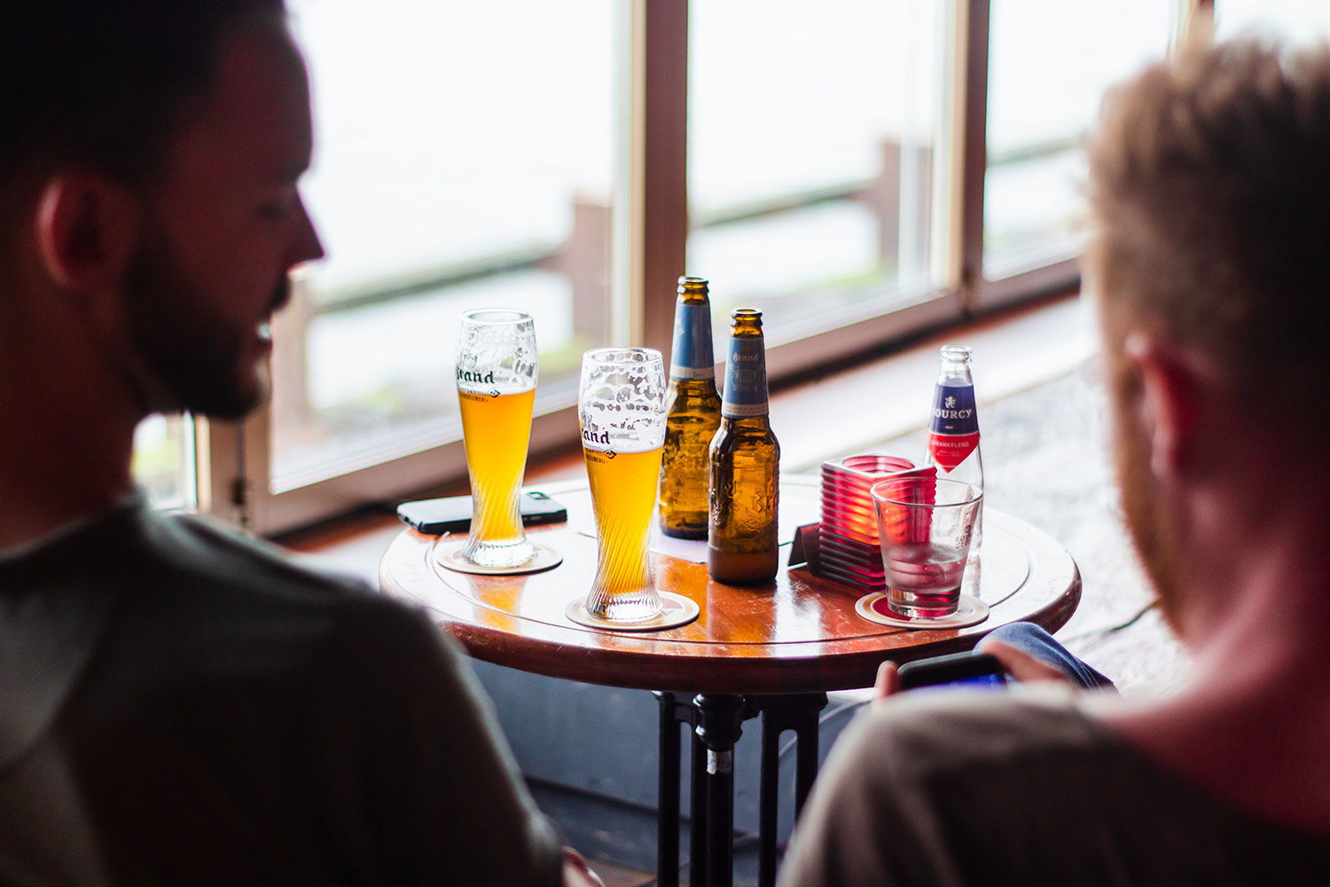 2 men sitting with alcoholic drinks