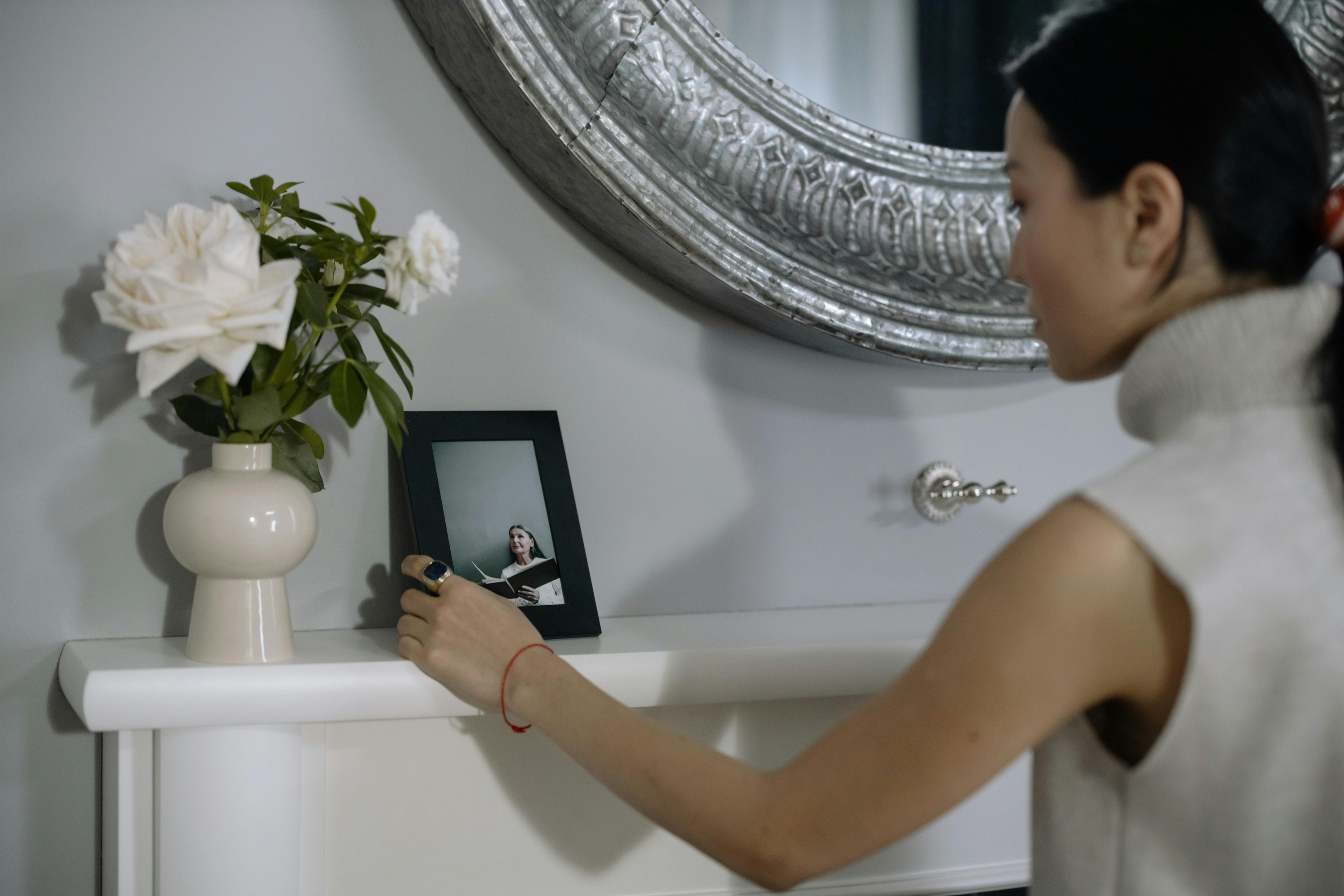 Girl looking at photo on mantel piece