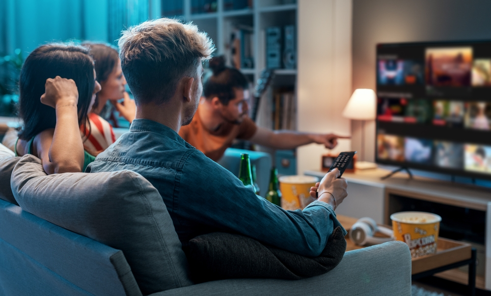 Friends sat with popcorn watching tv