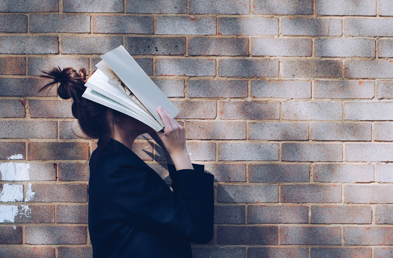 Person holding a book in their face