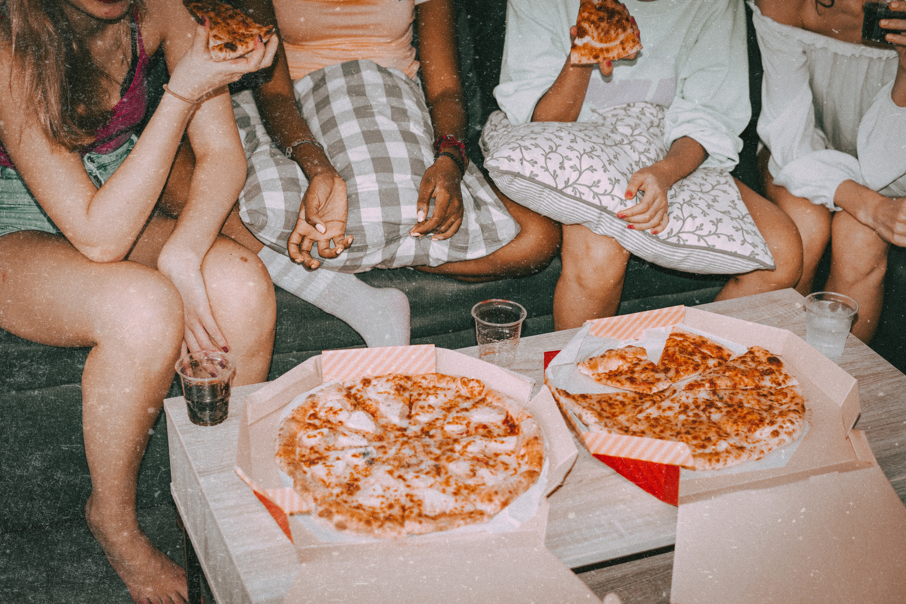 Friends sat around eating pizza