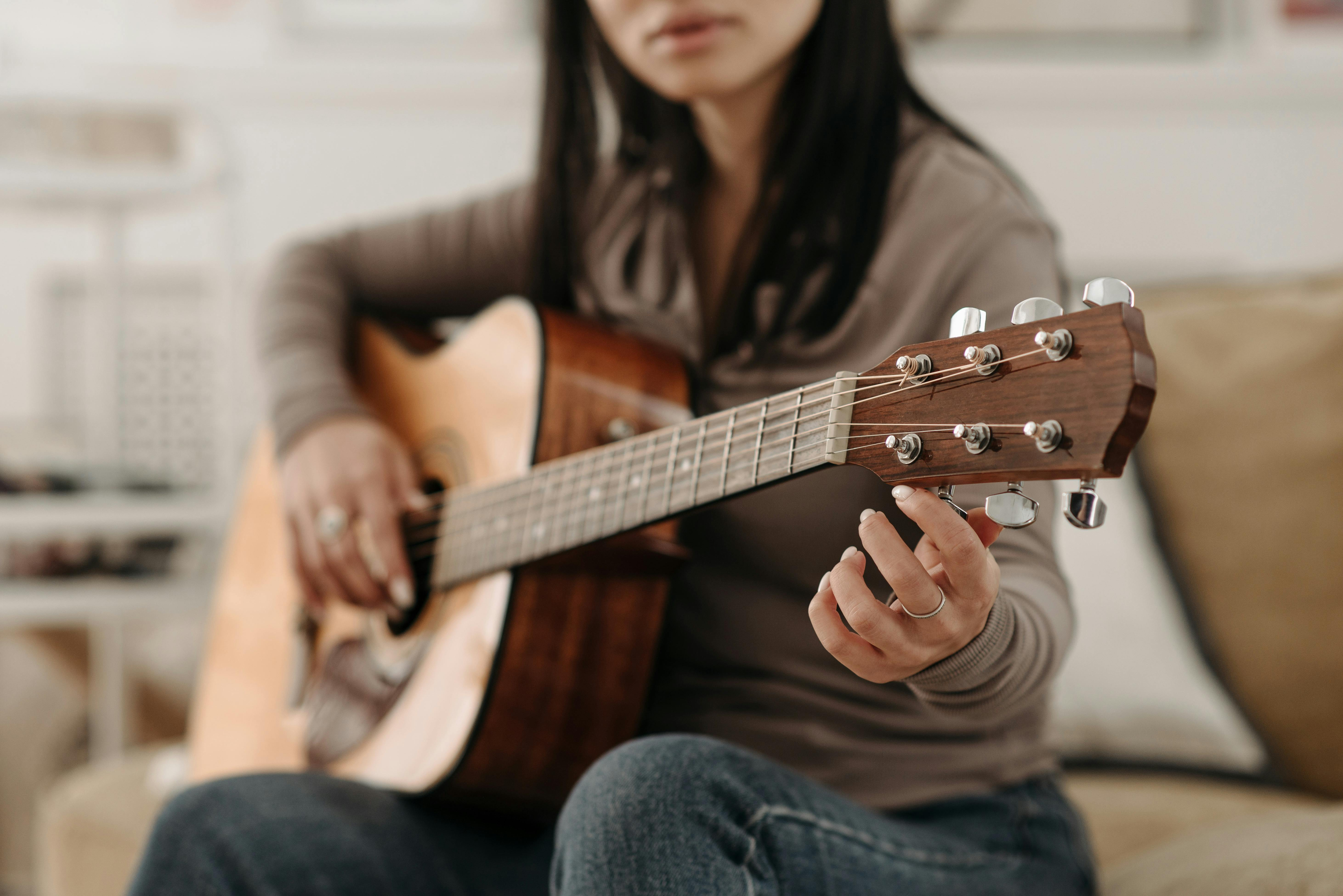 Woman tuning guitar