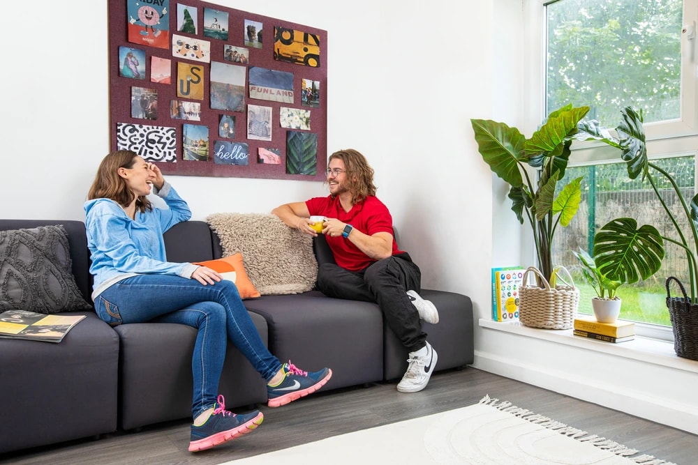 Students sat on sofa in shared kitchen 