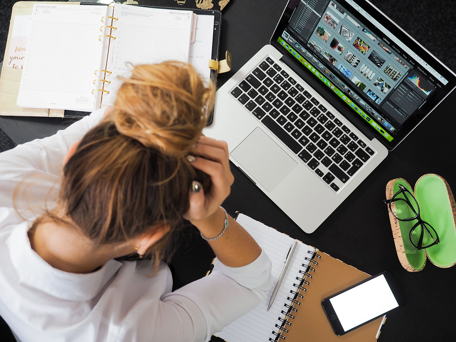 Woman at computer with head in hands