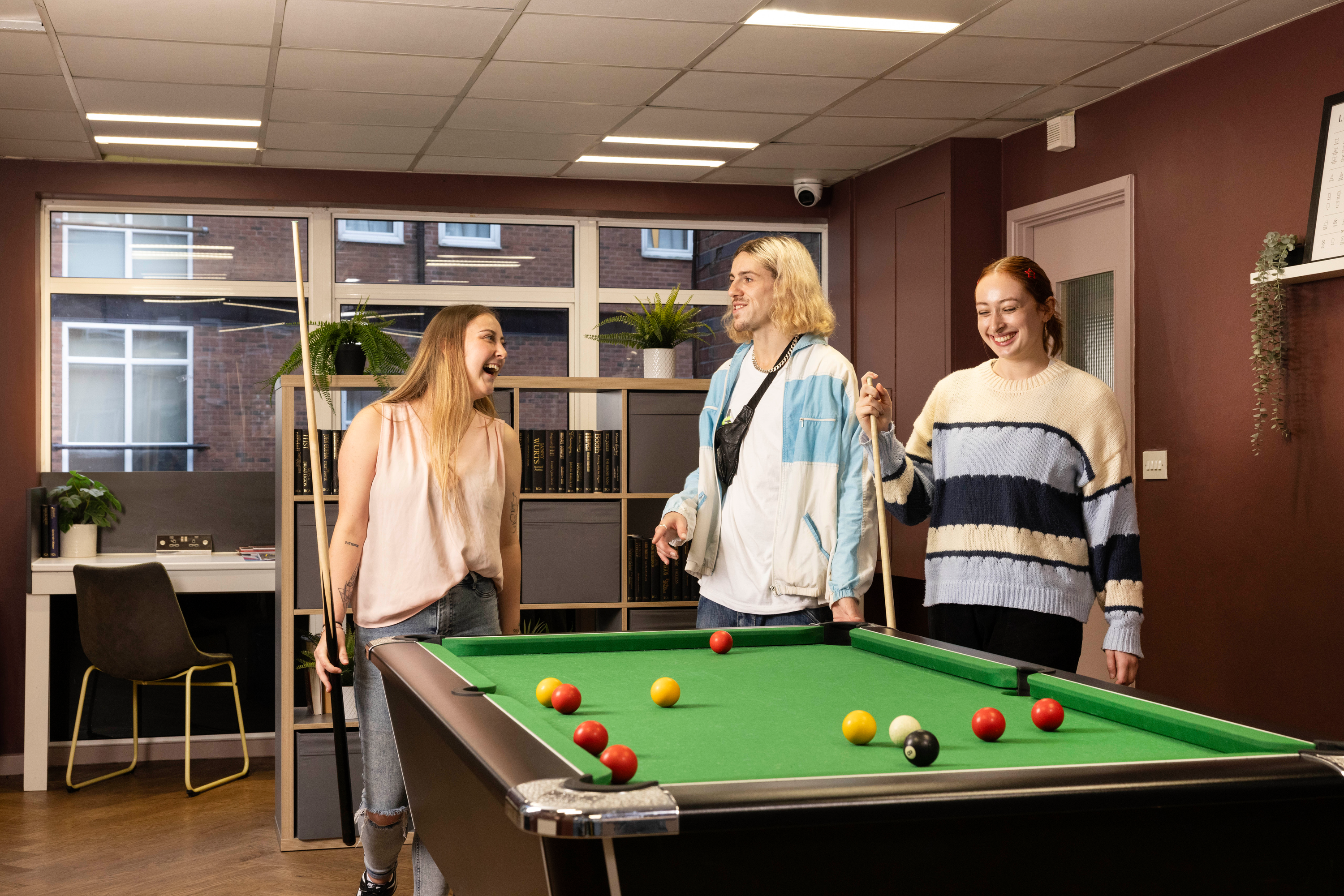 Students playing pool in common room 