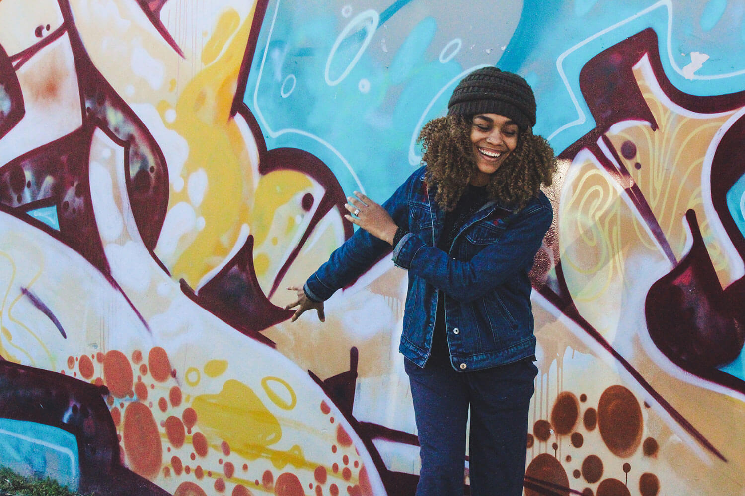 Woman dancing infront of graffiti wall