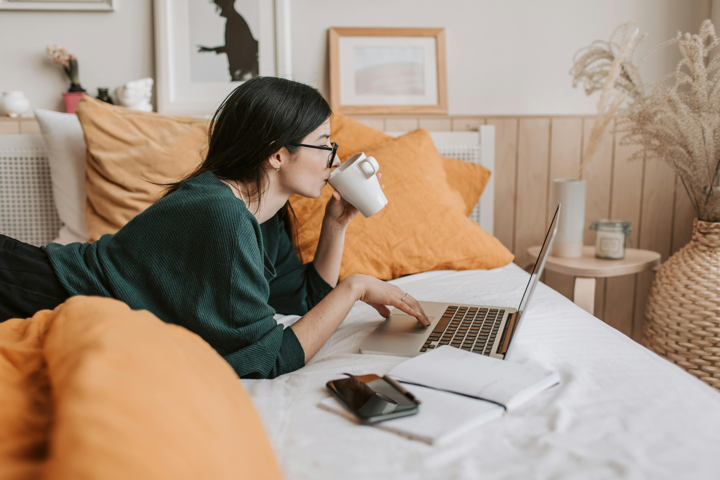 Girl led on bed with laptop