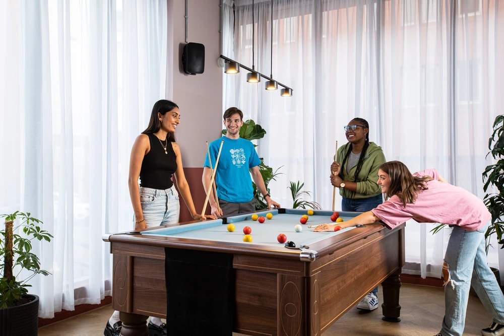 Students in games area playing pool