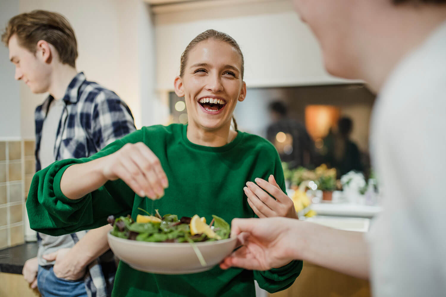 Women sprinkling over a bowl of food