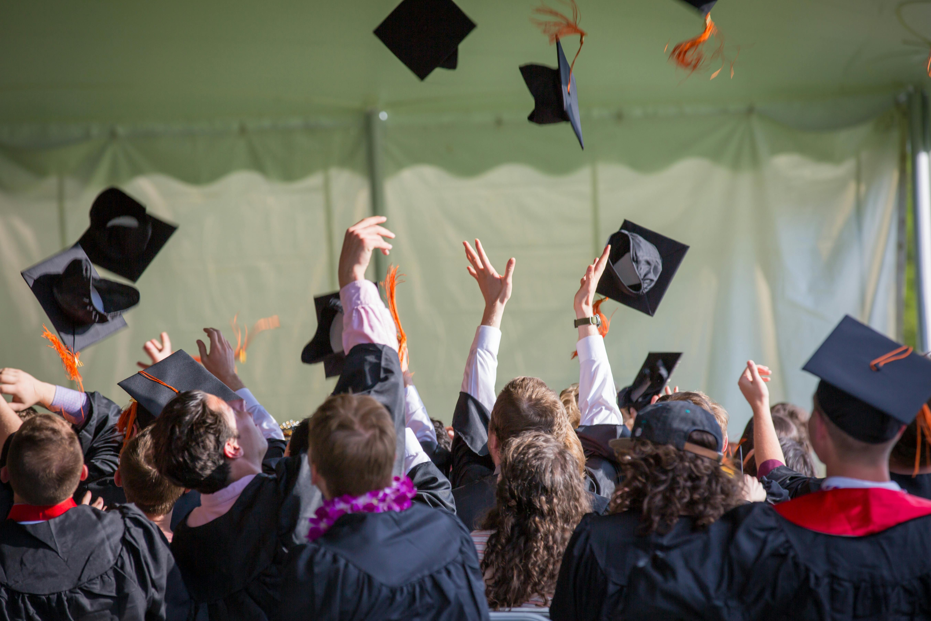 Students at graduation throwing caps