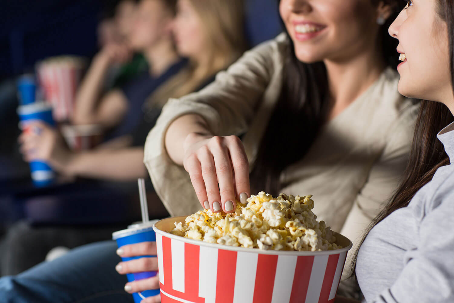 Two friends at the cinema eating popcorn