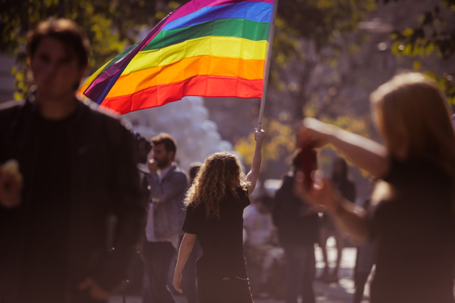 Person carrying a pride flag at a parade