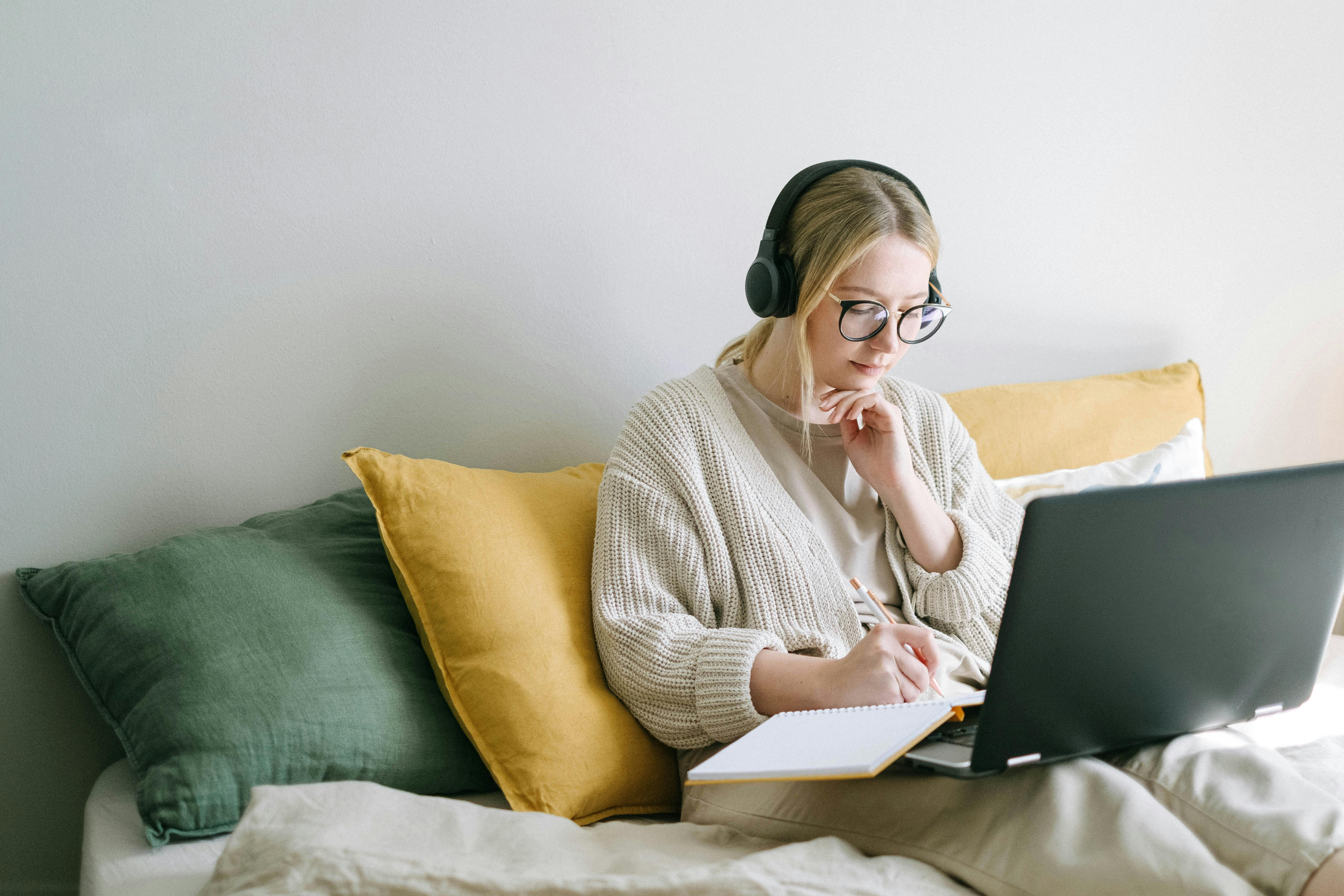 Girl sat on bed with laptop