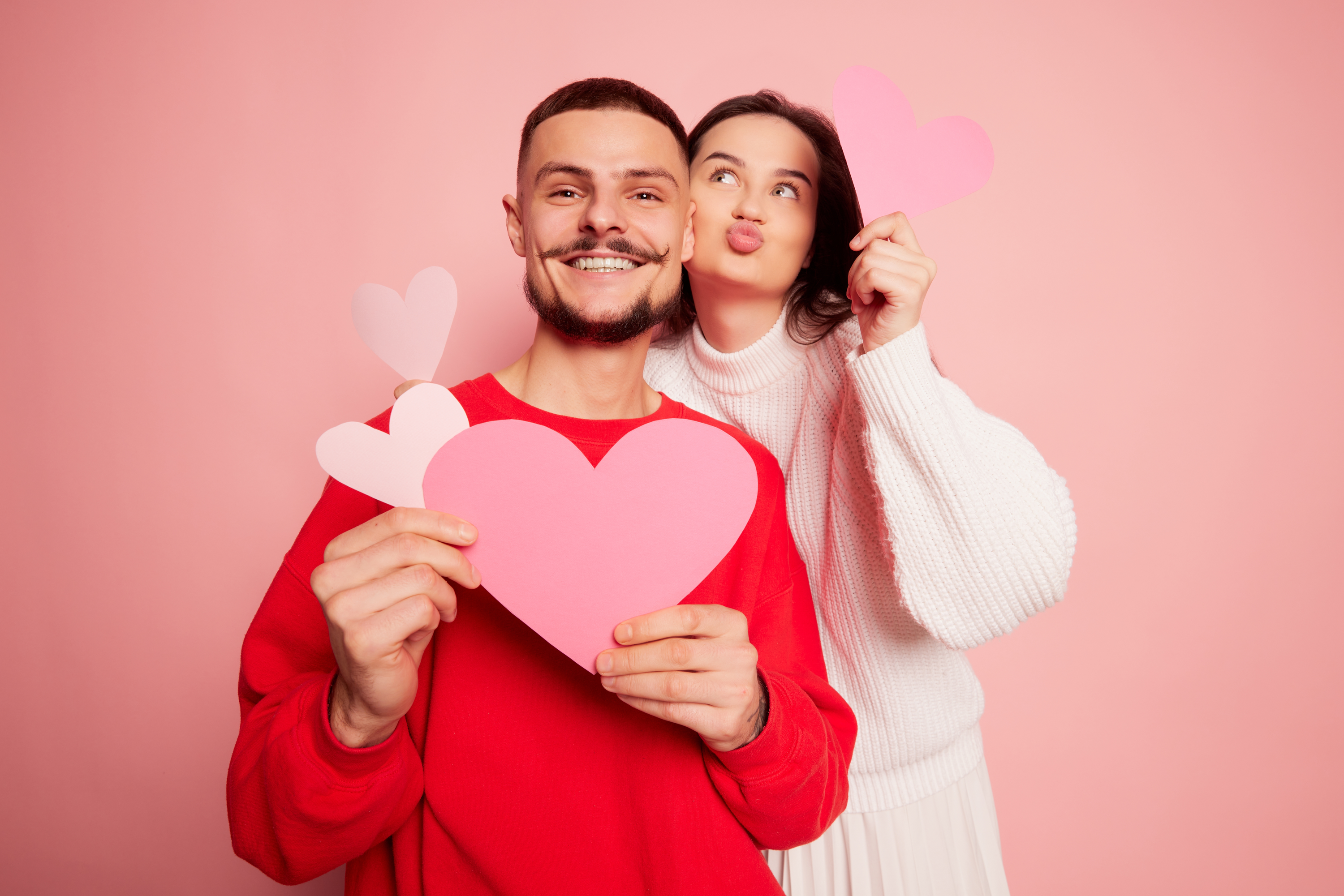 Girl and boy holding paper hearts