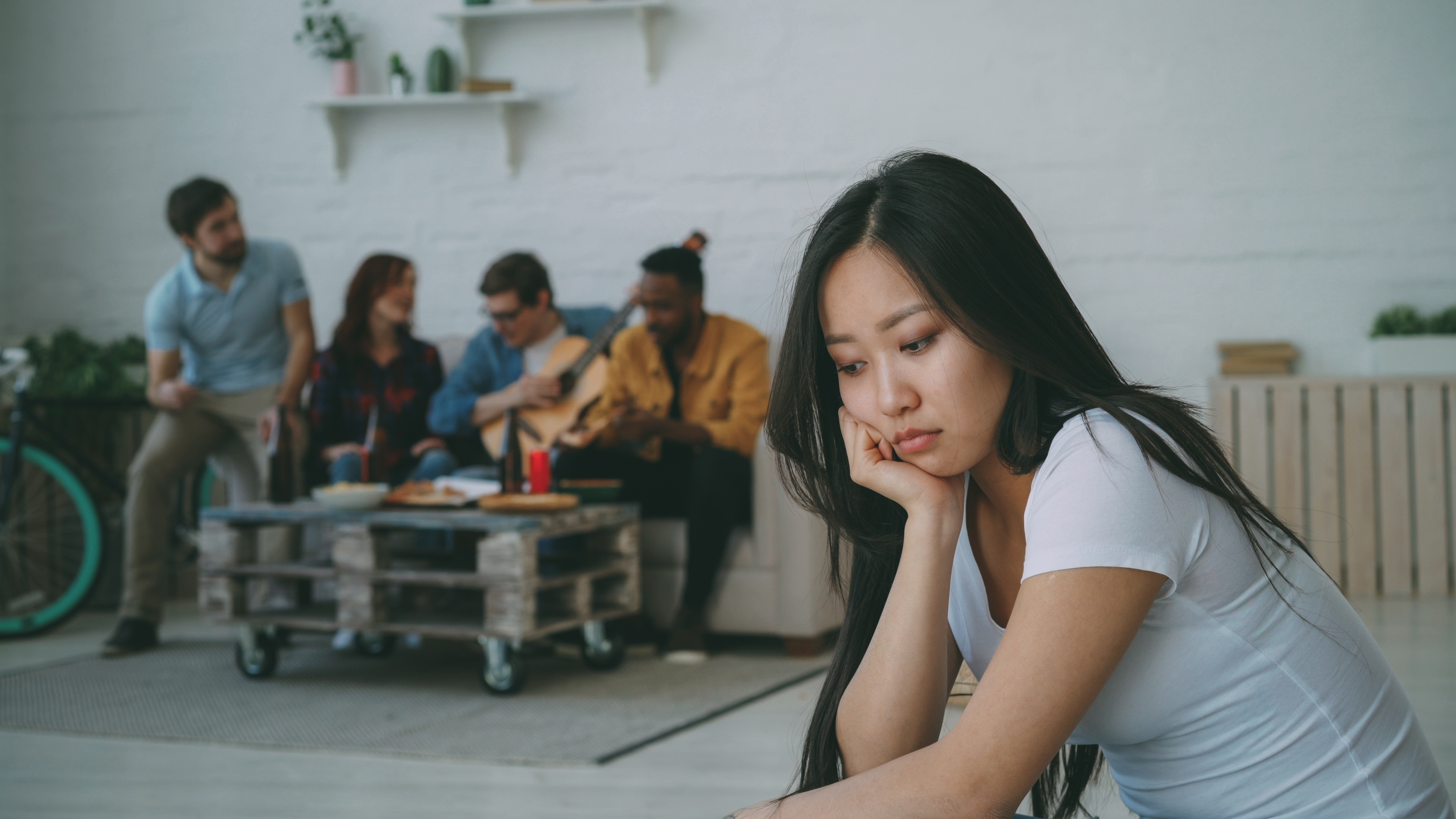 Girl sat on her own away from friends